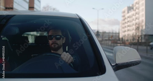 Man texting while driving car in the city downtown traffic