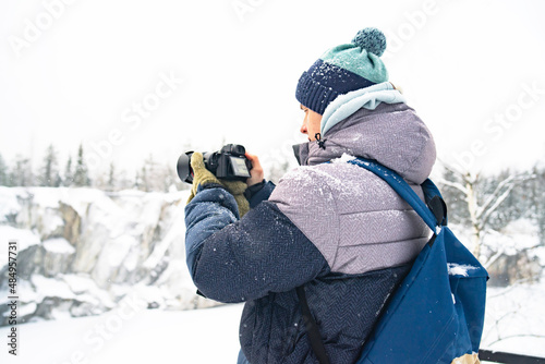 Portrait, The guy photographs the winter landscape in a mountain park, a panoramic scenic view photo