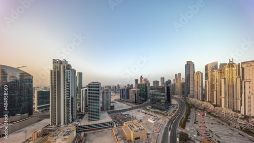 Fototapeta Naklejka Na Ścianę i Meble -  Bay Avenue with modern towers residential development in Business Bay aerial panoramic timelapse during sunrise, Dubai