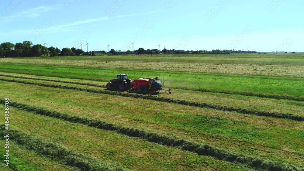 Treker mit einer Stroh Festkammerpresse bei der Strohernte auf einem gemähten Feld Treker mit einer Stroh Festkammerpresse bei der Strohernte auf einem gemähten Feld