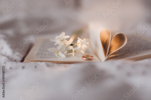 Wedding golden ring and open book with folded sheets in heart shape. Wedding concept, Valentines Day