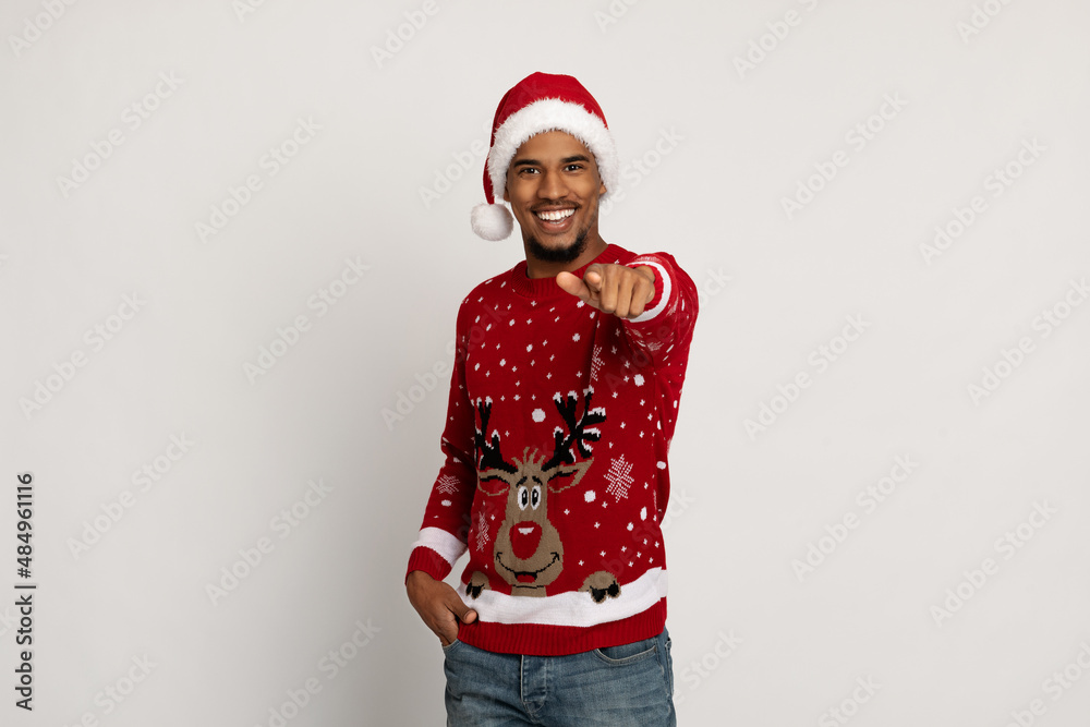 Charismatic handsome black guy in Santa hat pointing at camera Charismatic handsome black guy in Santa hat pointing at camera