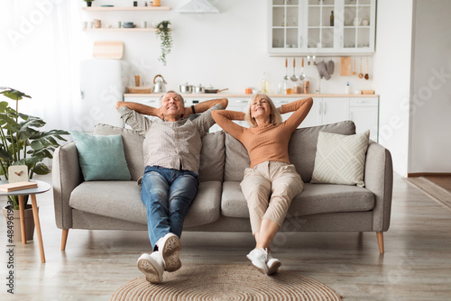 Fotografie Happy Senior Couple Relaxing Sitting On Sofa At Home