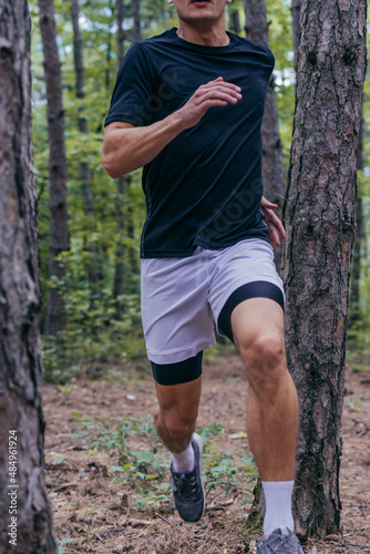 Close up picture of a handsome jogger jogging in the forest