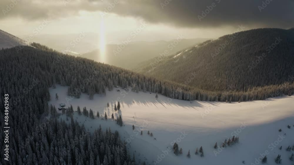 Mount Khomyak in the Carpathians, Hoverla and Petros Chernogora on the horizon, the sun's rays at sunset - a rare occurrence, fog, wild forests. Panorama from drone. Mount Khomyak in the Carpathians, Hoverla and Petros Chernogora on the horizon, the sun's rays at sunset - a rare occurrence, fog, wild forests. Panorama from drone.