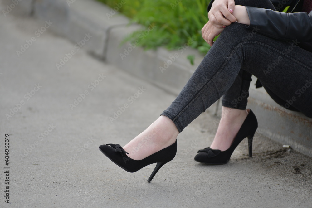 women's feet in black stilettos