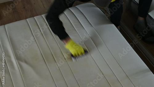 Male Worker Cleaning a mattress With Vacuum Cleaner.Professionally extraction method. Upholstered furniture. Mattress chemical cleaning.