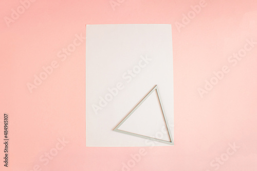 Triangle frame and FLYER A4 mock up blank template design idea. Triangle frame mockup against pastel pink background. Copy space templates designs for message. 3D illustration layout.