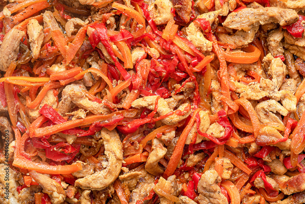 Full frame of pork meat is stewed in a pan with peppers, carrots, onions. Full frame of pork meat is stewed in a pan with peppers, carrots, onions.