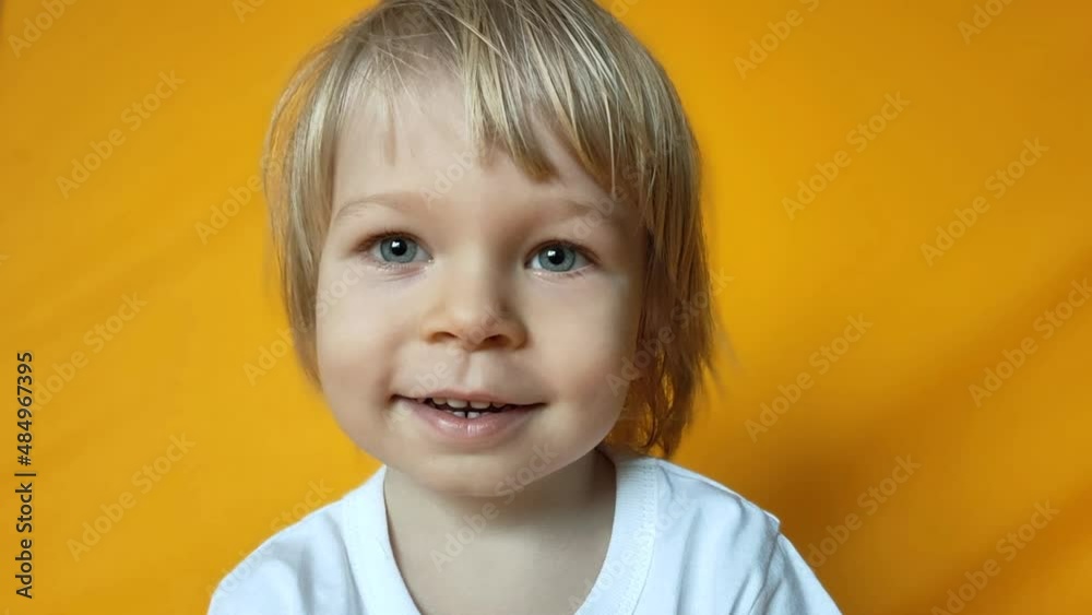 Little cute boy is having fun isolated on yellow studio background. Spring holiday concept Little cute boy is having fun isolated on yellow studio background. Spring holiday concept