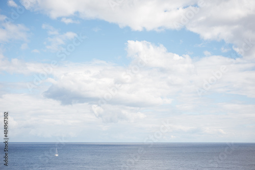 Sea and sky view with little white boat.