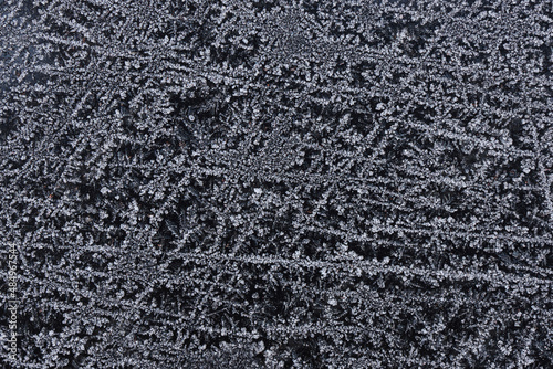 Frozen pattern of hoarfrost and frostwork structure on the dark glass. Color photo for background. No2.