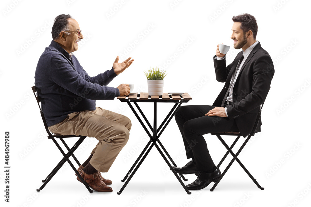 Fototapeta premium Businessman and a mature man sitting at a cafe table and having coffee
