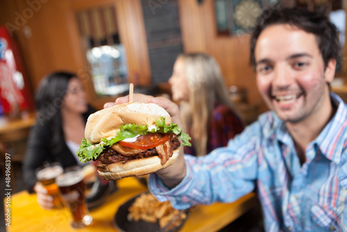 Young Man showing his burger in a restaurant