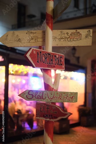 Snow covered sign pointing to the North Pole santa