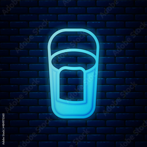 Glowing neon Bucket with rag icon isolated on brick wall background. Cleaning service concept. Vector
