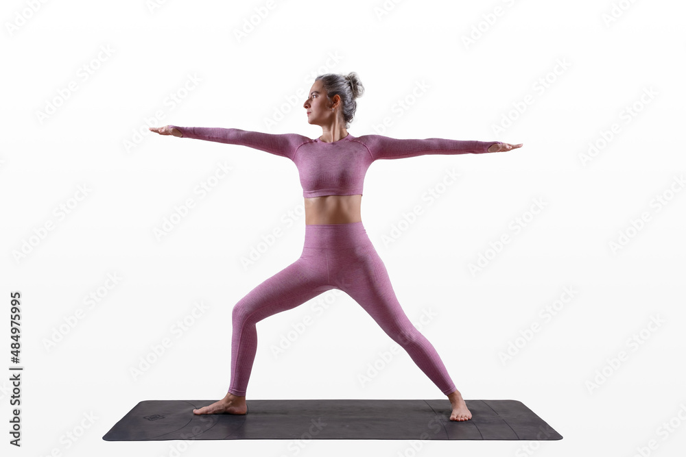 woman doing yoga - warrior two pose - virabhadrasana