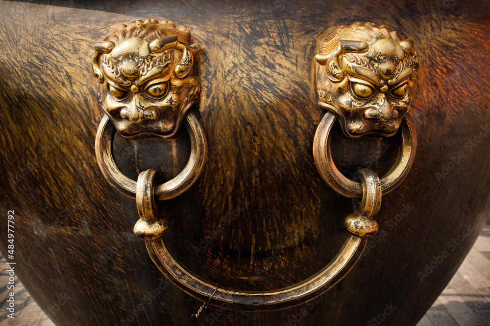 Bronze lion handles on the bronze water tank in side of the Forbidden city, the main buildings of the former royal palace of Ming dynasty and Qing dynasty in Beijing China.