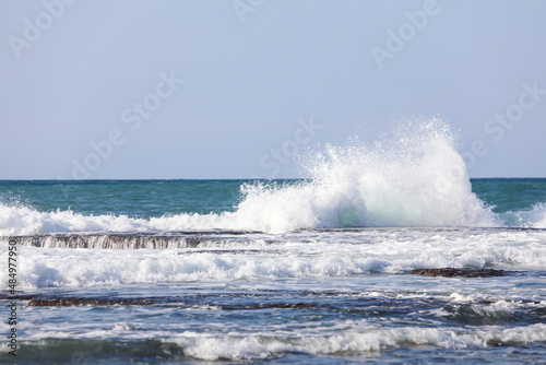 The big breaking waves during a strom at the beautiful summer sea shore background the blue sky and horizon. High quality photo photo