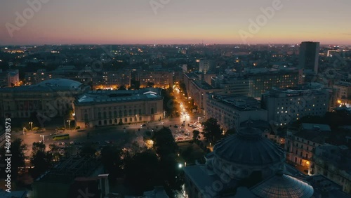 the sun sets over autumn bucharest. evening in a European city. urban active traffic in the old city - Aerial view  photo