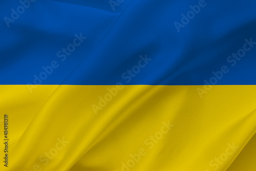 Ukraine flag on waving silk background. National flag with yellow and blue colors. Fabric texture.