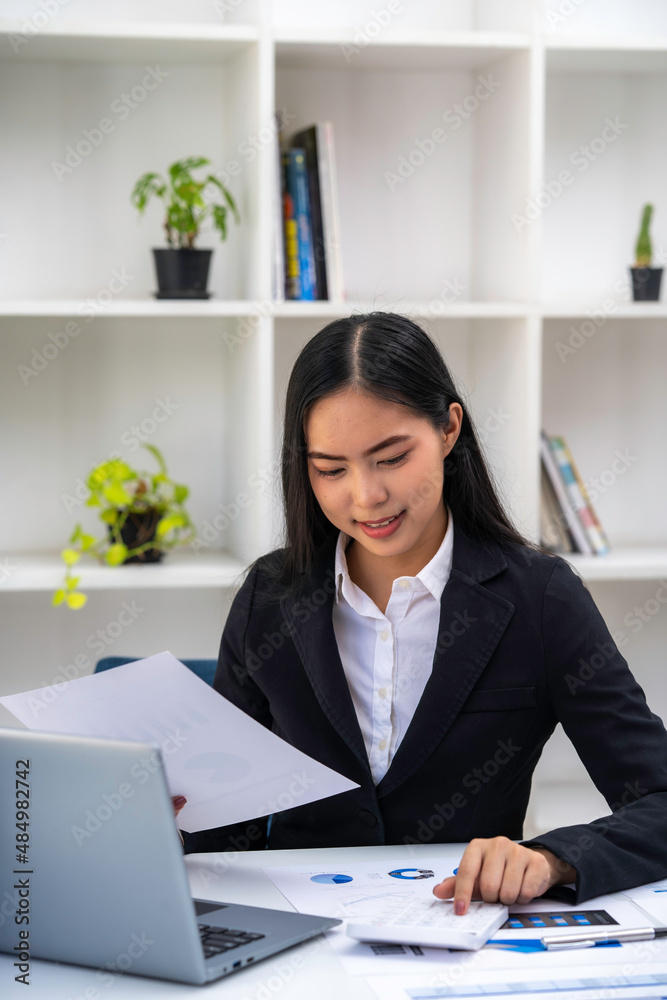 Asian businesswoman working on tablet and taking notes, accountant use a computer laptop at work in the office. Asian businesswoman working on tablet and taking notes, accountant use a computer laptop at work in the office.