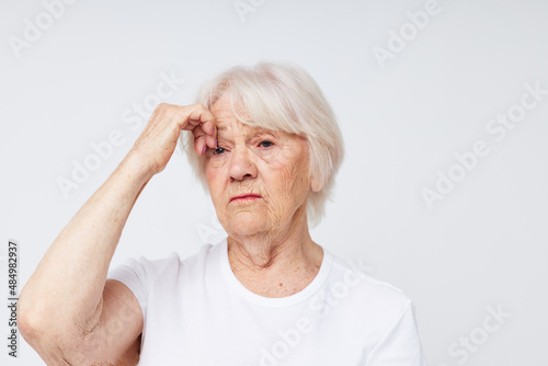 Photo of retired old lady holding his head discontent problem light background