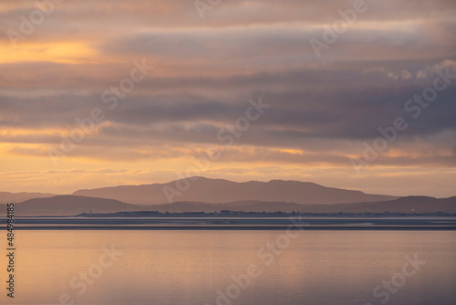 Beautiful sunset landscape image of Solway Firth viewed from Silloth during stunning Autumn sunset with dramatic sky and cloud formations