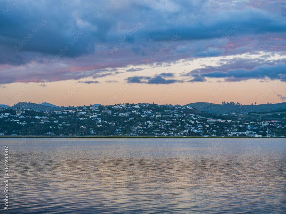 Knysna lagoon and town during a twilight sky and reflection on water in South Africa