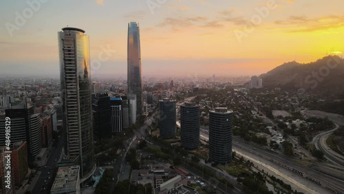 Aerial pan left of San Cristobal Hill and modern skyscrapers in Sanhattan area at sunset, Santiago, Chile photo