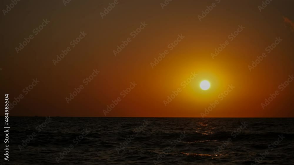 Sunset. The red sun sets over the horizon in a choppy sea. Sunset. The red sun sets over the horizon in a choppy sea.