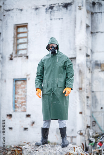 A man in a protective mask and protective clothing explores a dangerous radioactive area.