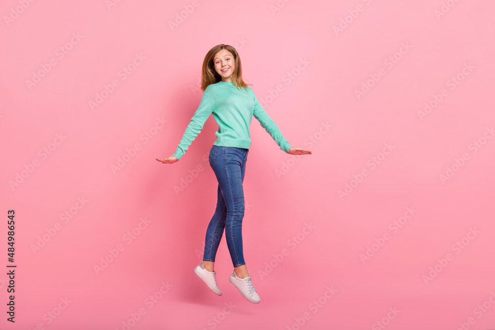 Photo of charming pretty girl wear turquoise sweater jumping high isolated pink color background