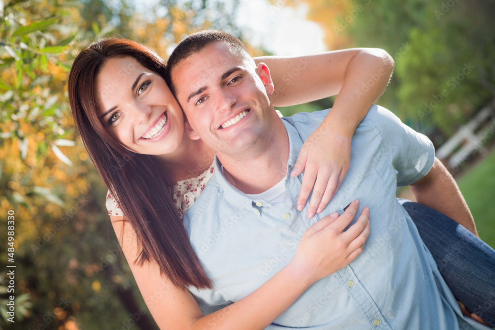 Happy Romantic Caucasian Couple Piggyback Riding in the Park. Happy Romantic Caucasian Couple Piggyback Riding in the Park.