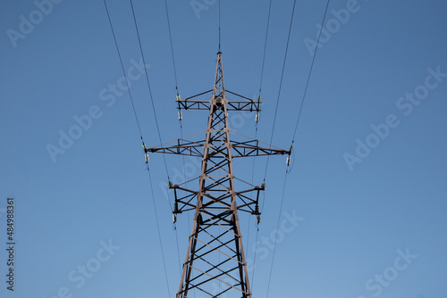 Steel  power line tower on a clear blue sky.