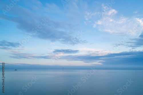 Cloudy blue minimalist seascape. Deserted space with horizon line.