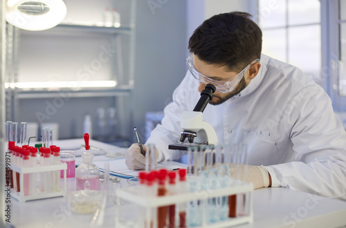 Картината върху платно Focused male young Caucasian assistant or technician work with test tube glass do research in lab