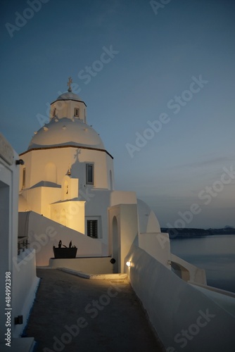 View of a whitewashed Greek Orthodox Church in Fira Santorini Greece while the sun goes down