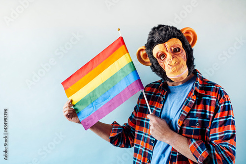 Foto Man in monkey mask holding gay flag.