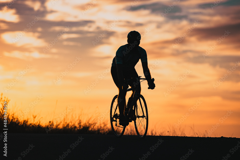 Obraz premium cyclist silhouette at sunset sports and fitness concept