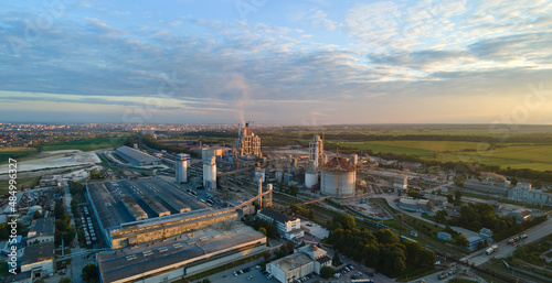 Aerial view of cement factory tower with high concrete plant structure at industrial production area. Manufacturing and global industry concept