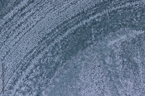 Frozen pattern of hoarfrost and frostwork structure on car windshield glass. Color photo for background. 