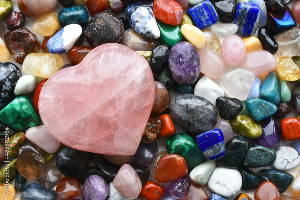 A top view image of a large variety of healing crystals with a large rose quartz crystal heart. A top view image of a large variety of healing crystals with a large rose quartz crystal heart.