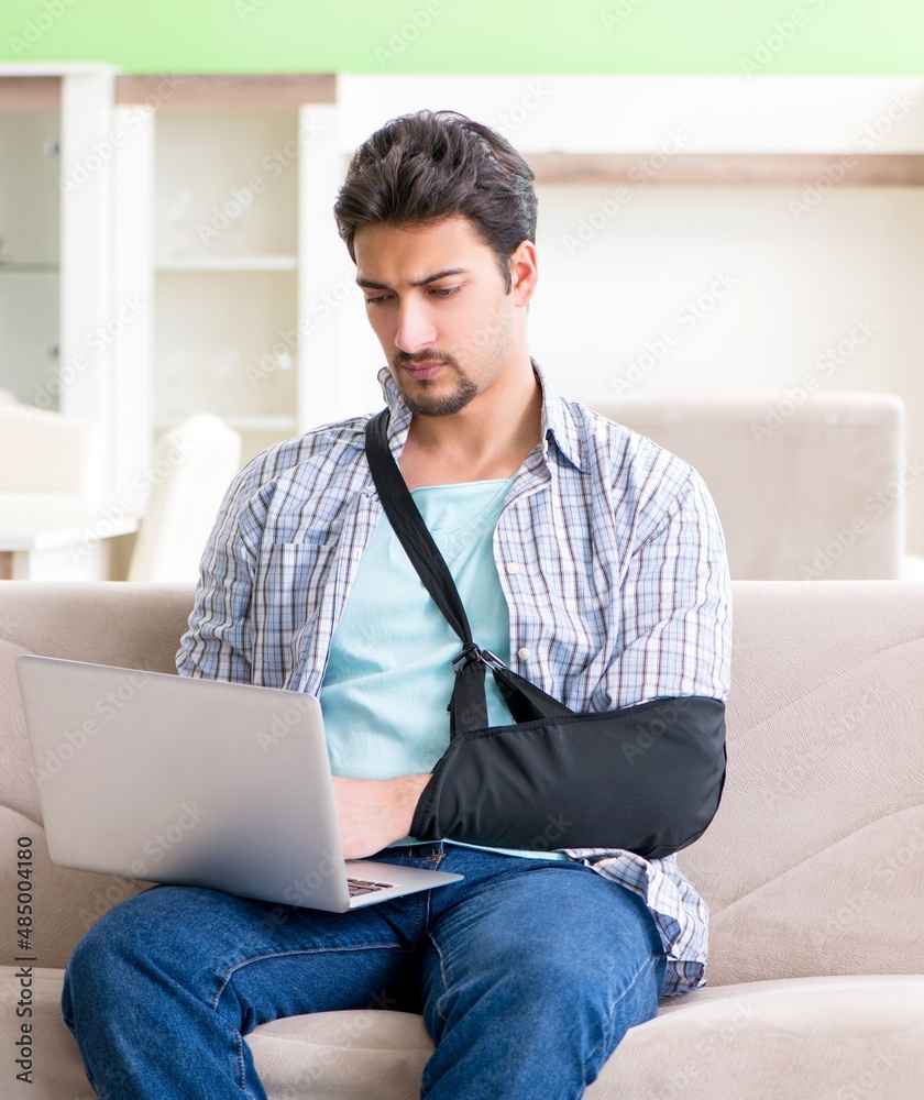 Young student man with hand injury sitting on the sofa