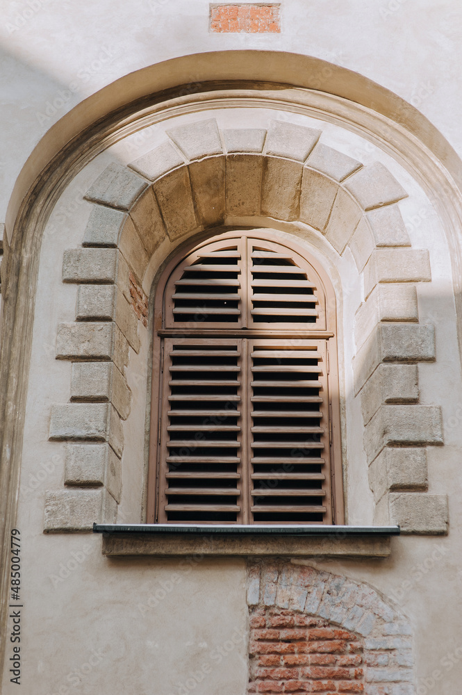 Old vintage arched window with wooden shutters. Armenian Church, Lviv.