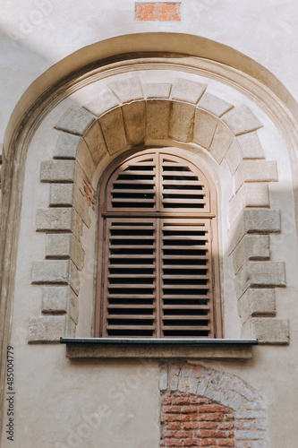 Old vintage arched window with wooden shutters. Armenian Church, Lviv. © shchus