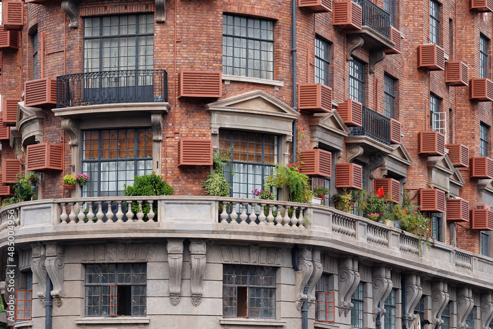 Close up view of Shanghai Wukang mansion, red brick wall and beautiful windows and flowers.