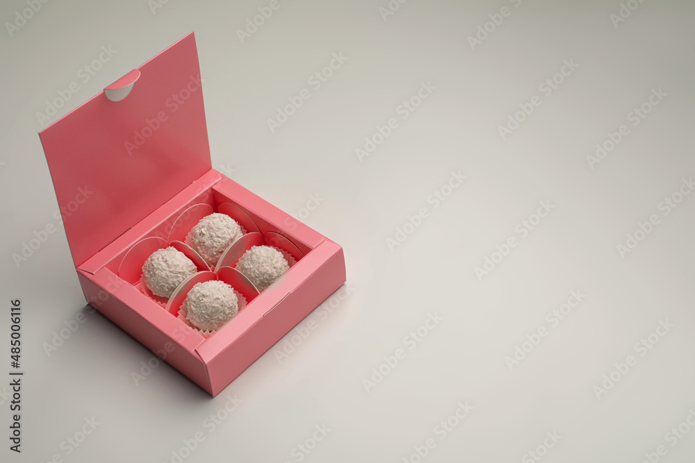 Delicious candies in pink box on light grey background, space for text Delicious candies in pink box on light grey background, space for text