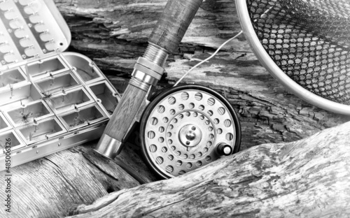 Vintage fly fishing outfit on rocks and wood background
