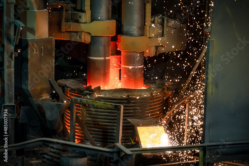 Fotografie Electric arc steelmaking furnace, thick powerful red-hot graphite electrodes